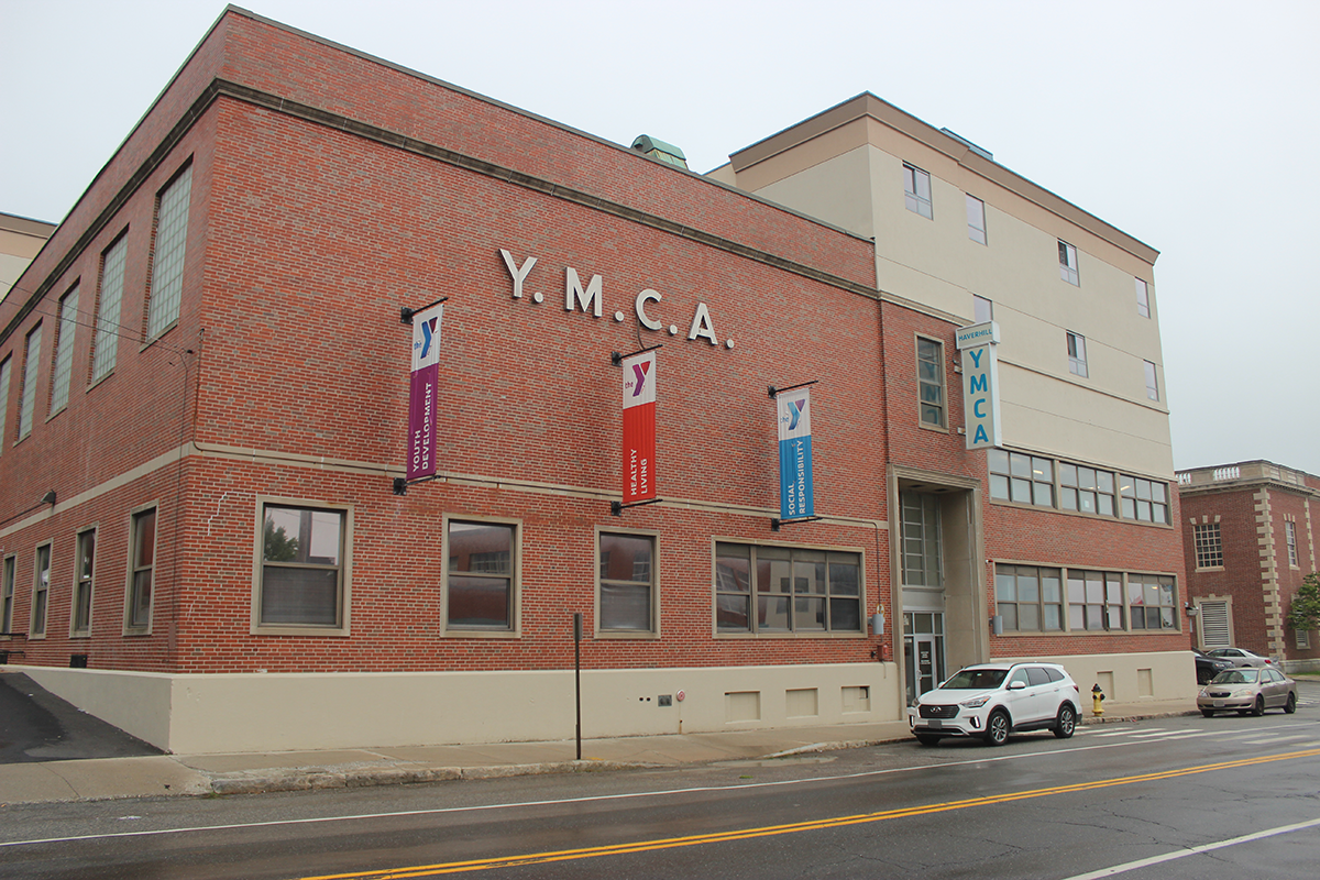 An exterior view of the red brick Haverhill YMCA with YMCA on the side in large beige letters.