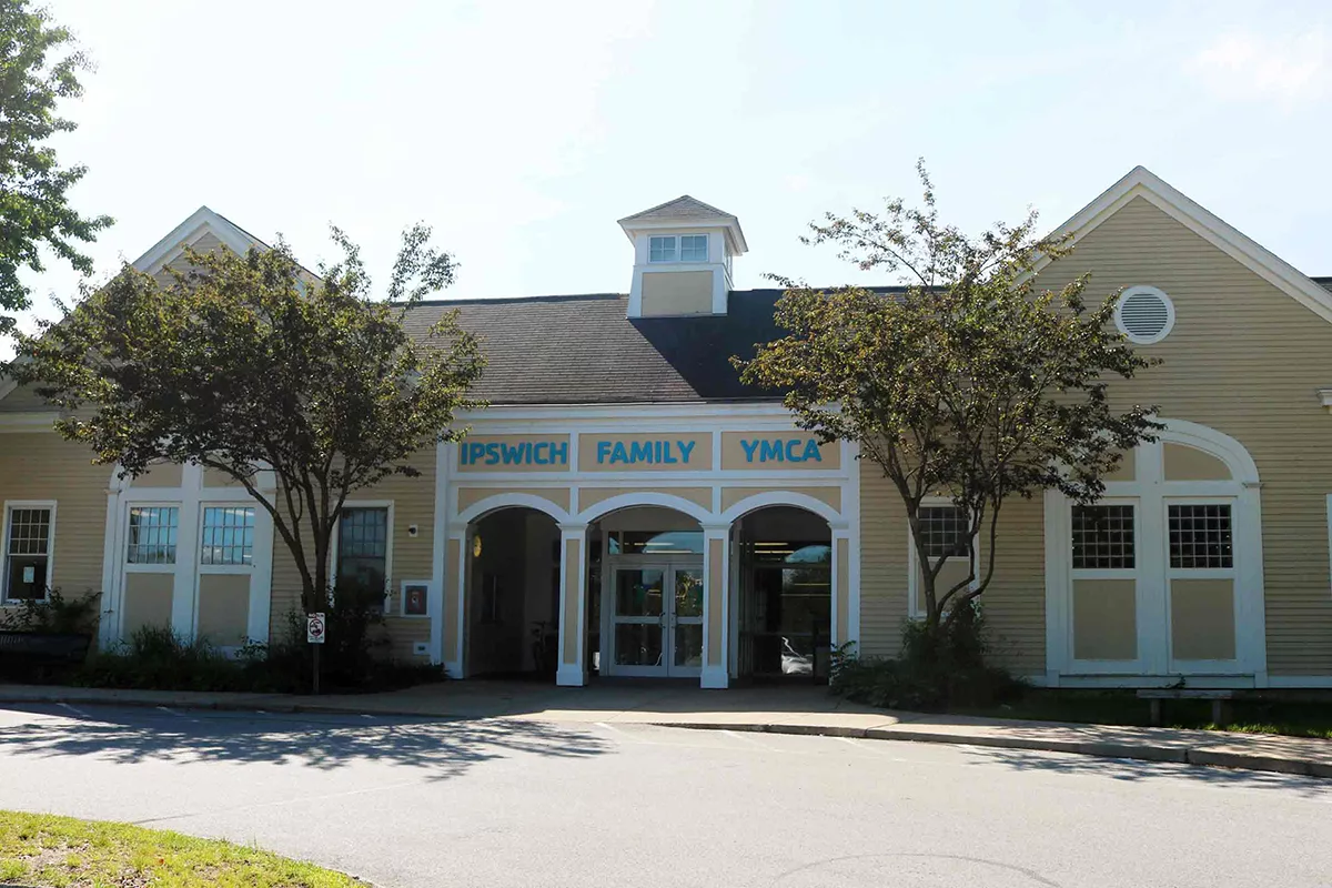 A photo of the front of the yellow, craftsmen-style Ipswich Family YMCA